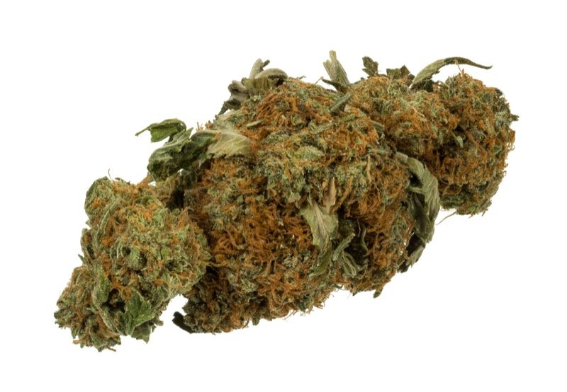 Broken-up cannabis flower spread on a surface, ready for decarboxylation in the oven
